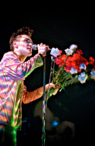 Morrissey on stage with flowers.